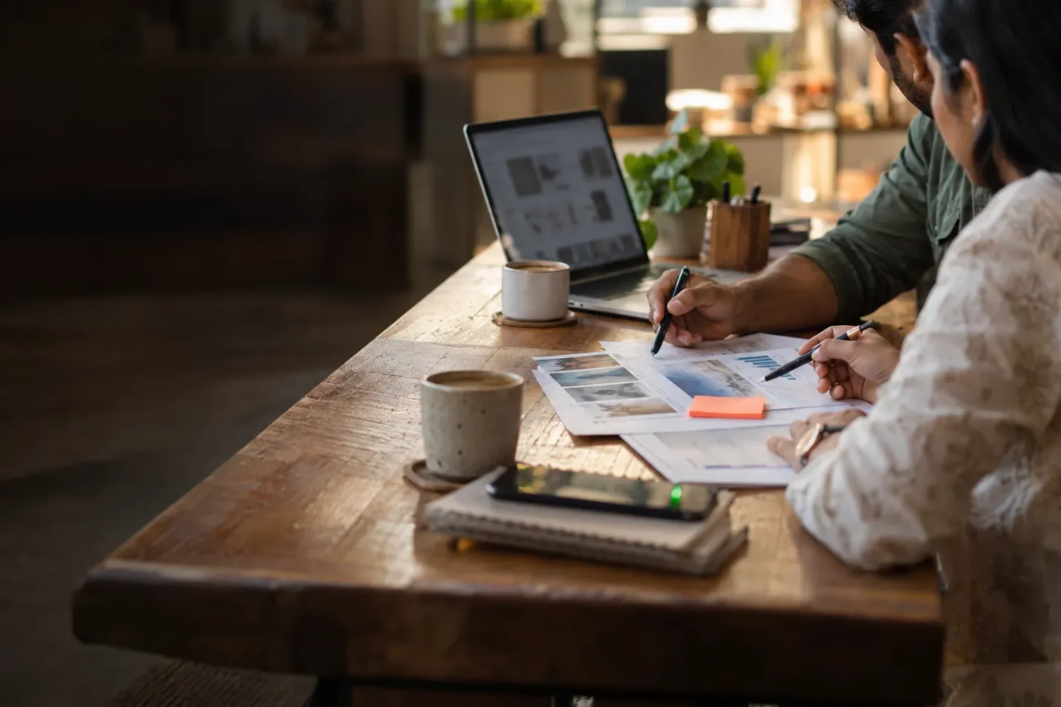 Two colleagues reviewing a printed proposal across a table